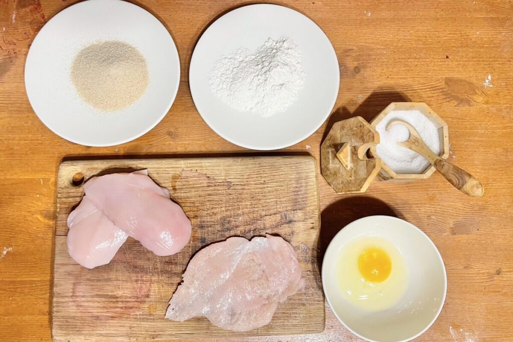 Ingredients to make a chicken schnitzel.