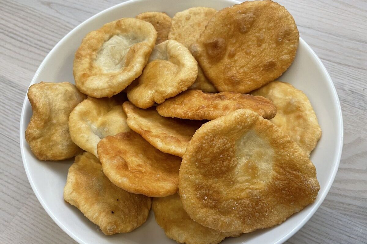 Golden dough snacks in a white bowl.