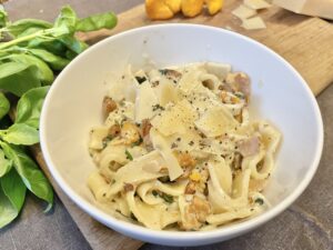 Served chanterelle pasta in a white bowl.