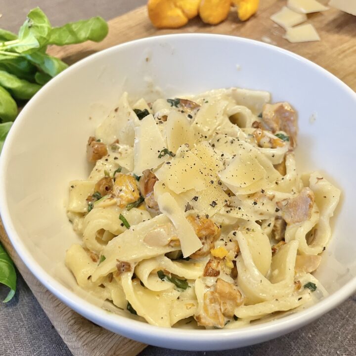 Served chanterelle pasta in a white bowl.