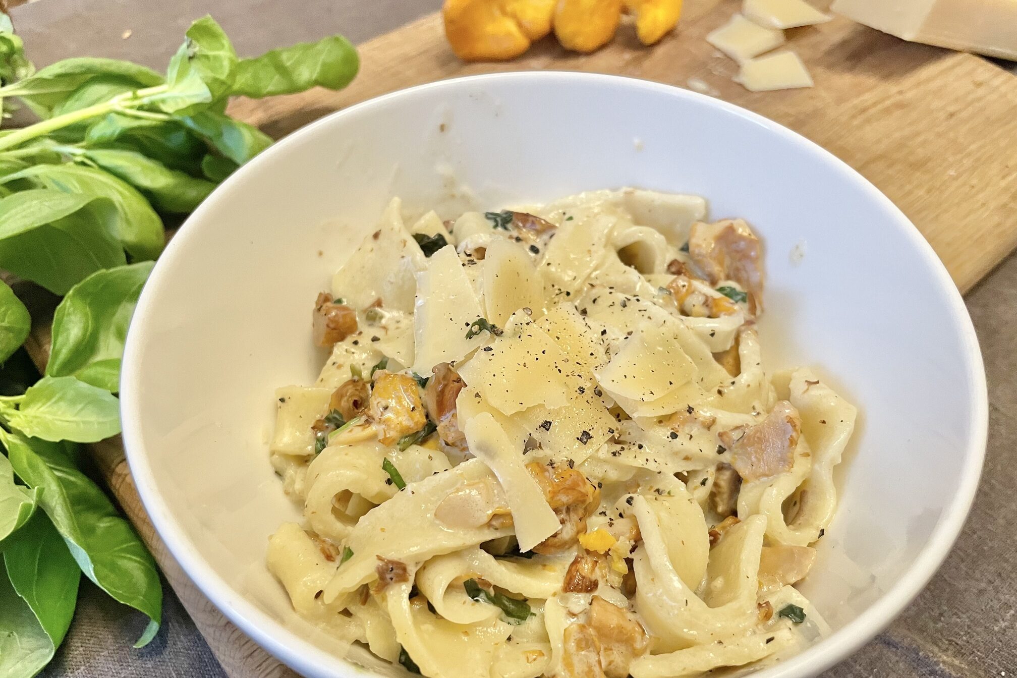 Served chanterelle pasta in a white bowl.